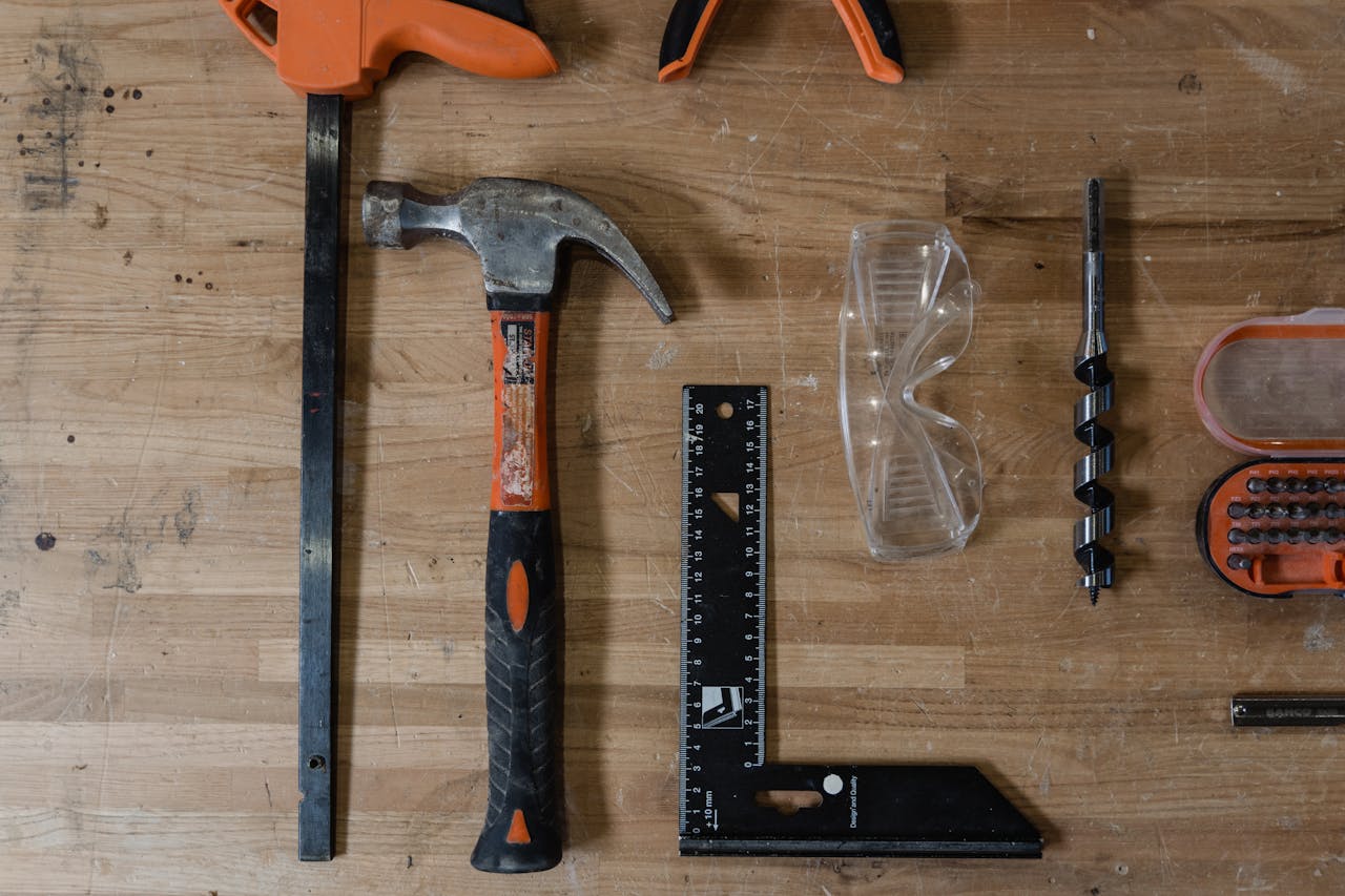 Flat lay of essential carpentry tools on wooden table.